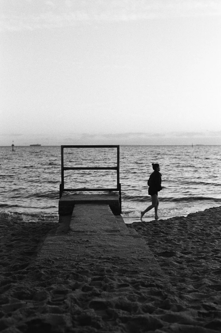 Analog photograph, figure on a beach by a frame
